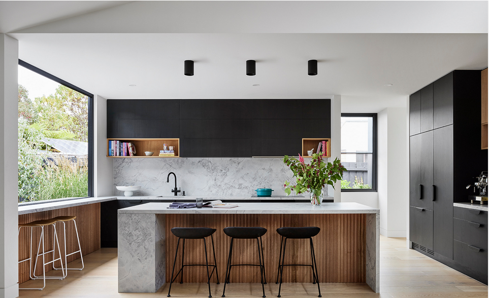 A bright, contemporary kitchen with a marble island and warm timber joinery